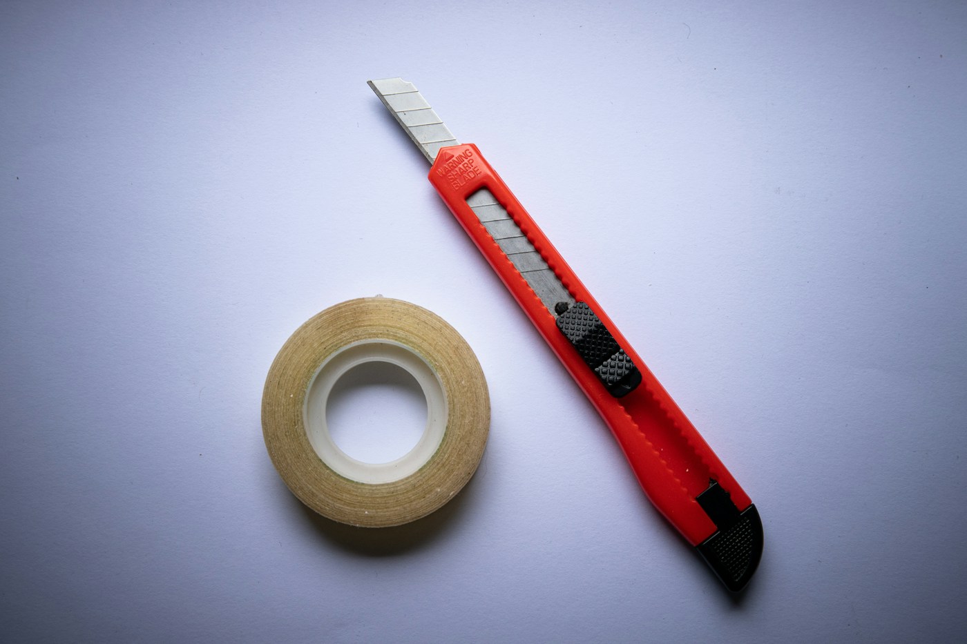 Roll of adhesive tape and a utility knife