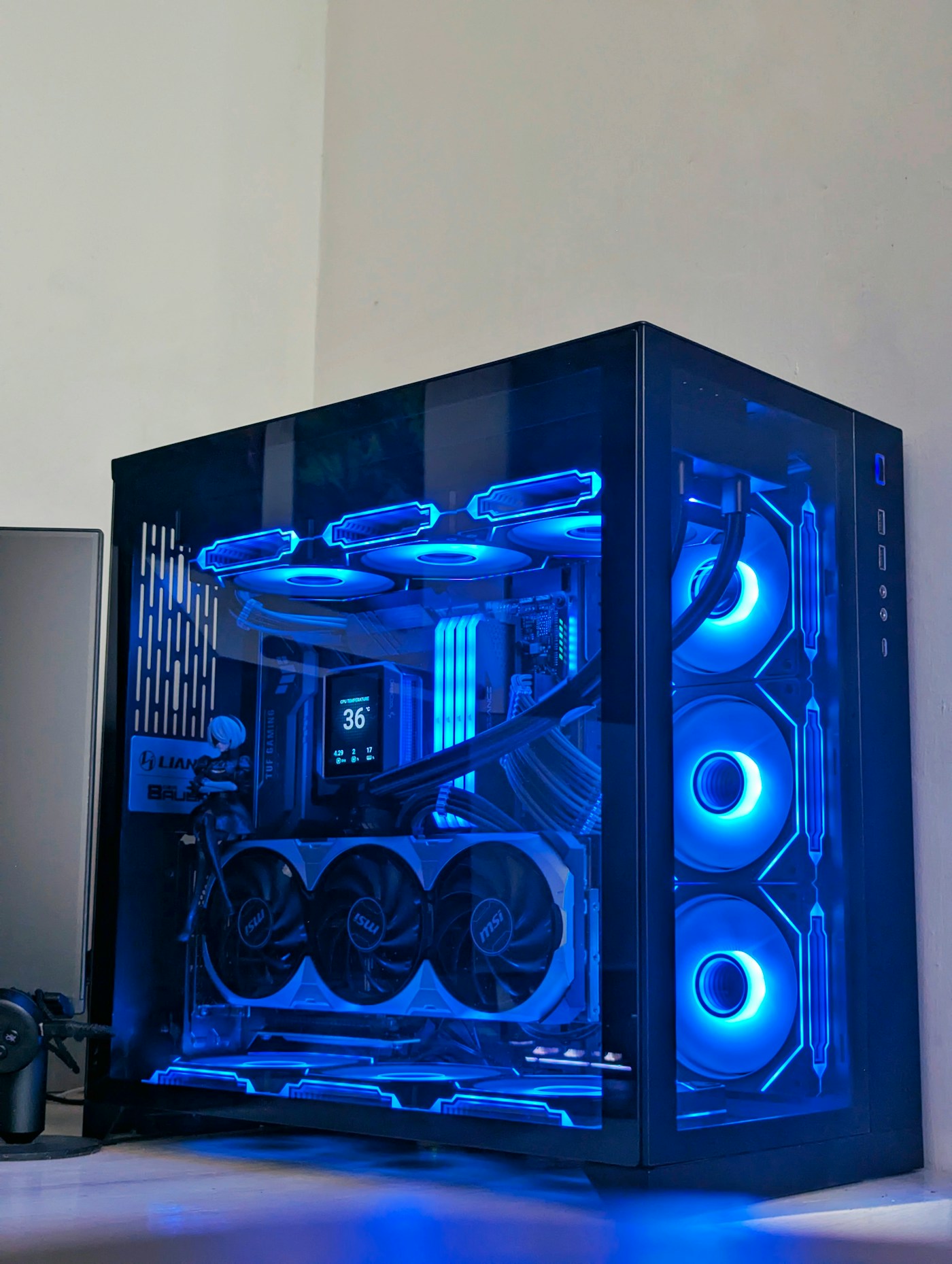 Black glass PC tower with blue RGB lighting on a desk